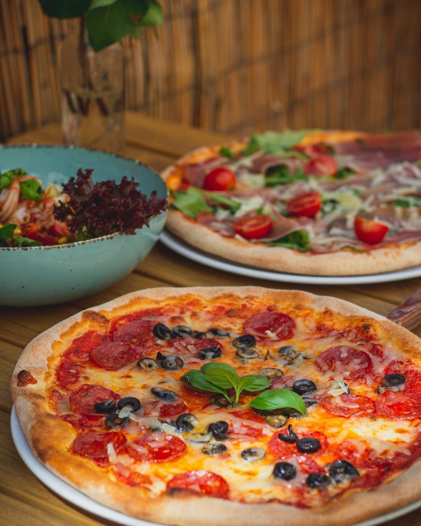 Freshly baked Margherita pizza with vegetables and cheese at Caffeine Tales